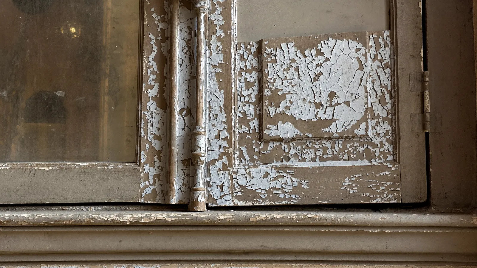 Ancienne peinture écaillée sur une boiserie d'un logement ancien, risque de plomb
