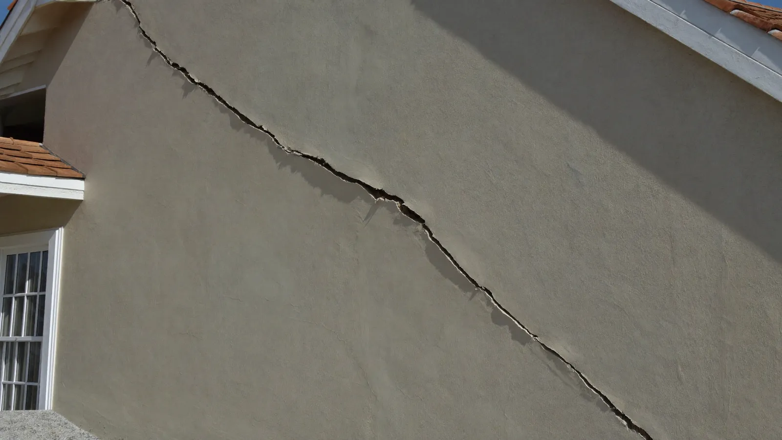 Fissure sur la façade d'une maison causée par le retrait-gonflement des argiles